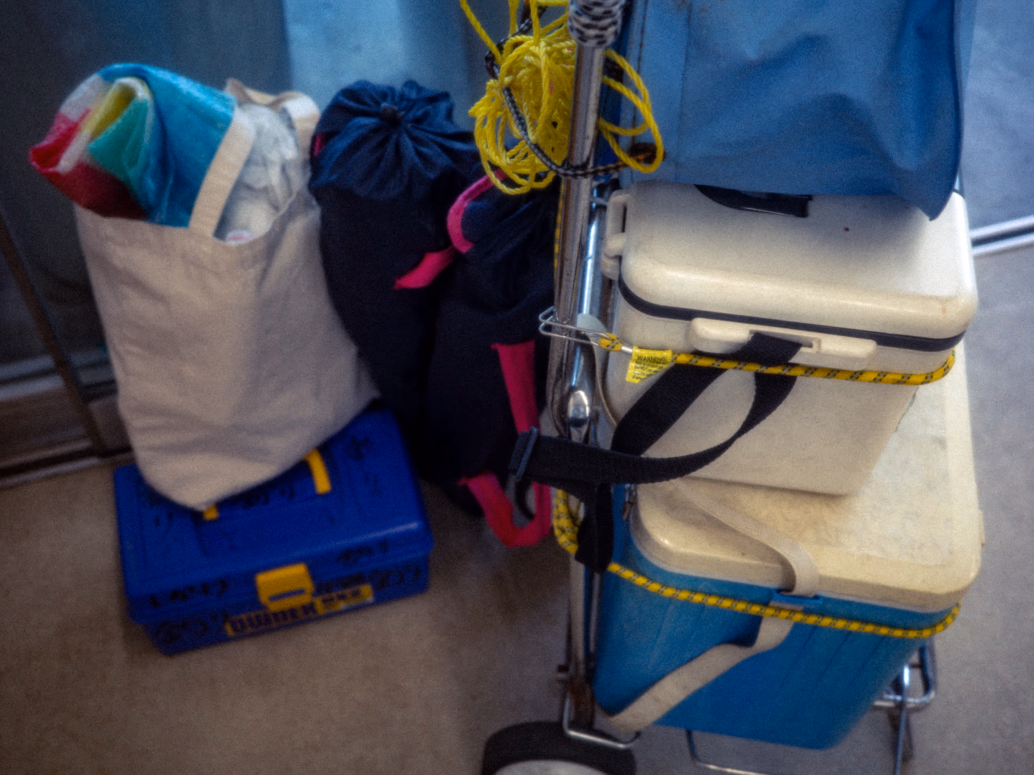 Cooler boxes, bags, and a fishing rod stacked at the entrance.